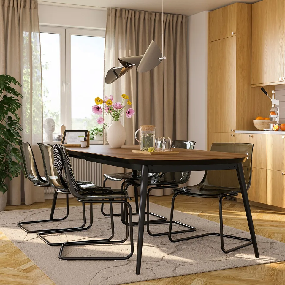 TJÄRKIL dark wood table with black chairs. Modern dining set with natural decor.