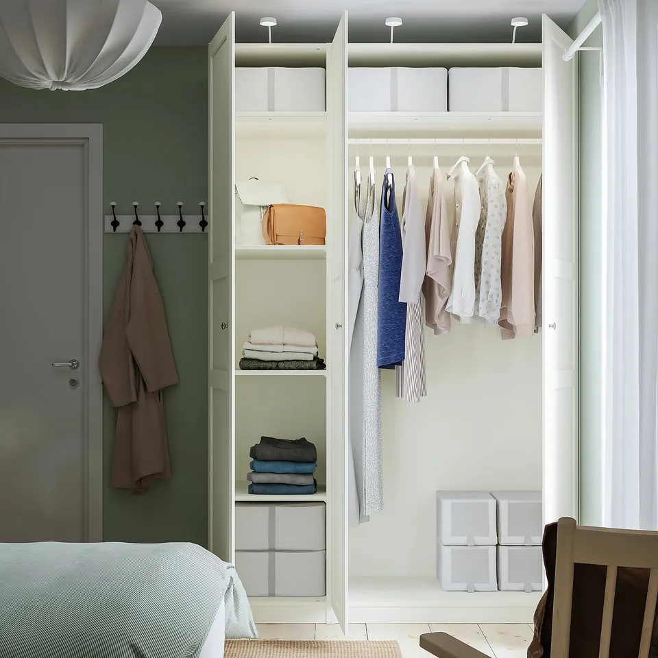Open wardrobe with clothes hangers, shelves, and storage boxes.