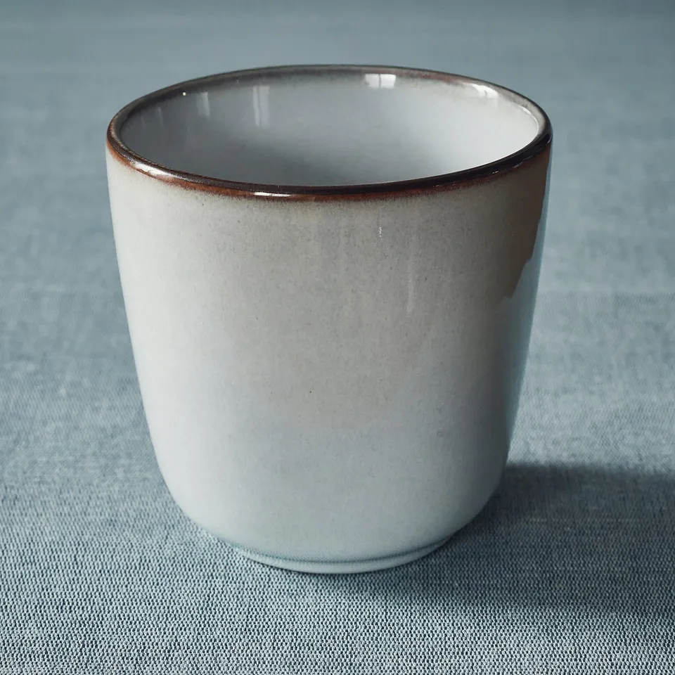 Brown-rimmed mug on blue surface