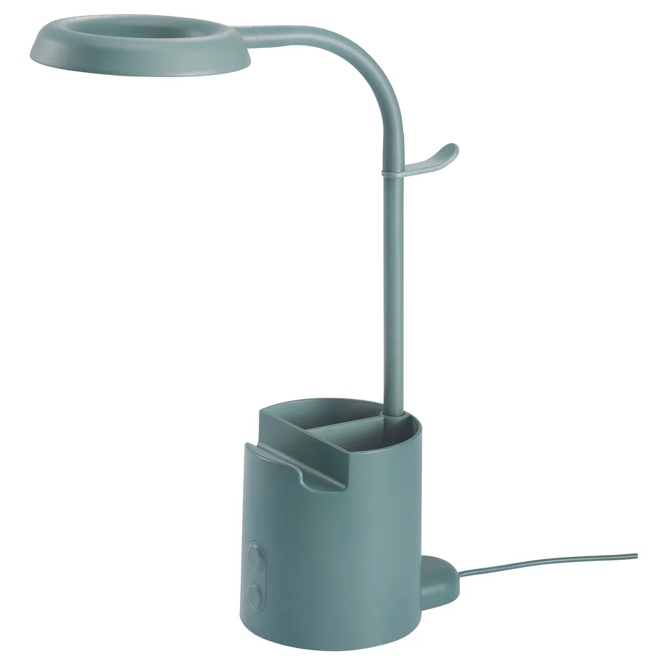Green BRUNBÅGE lamp with pen holder, adjustable arm, touch dimmer, phone holder, and headphone hook.