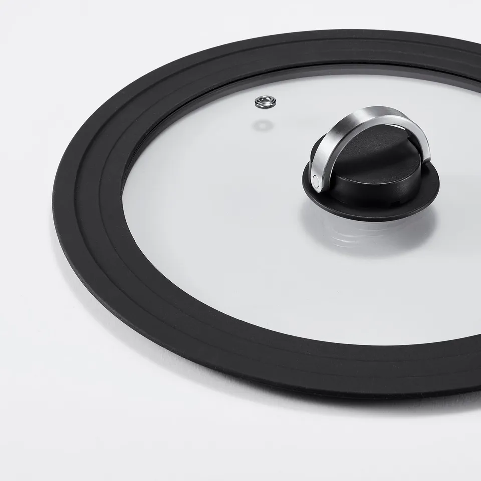 Clear glass pot lid with black silicone rim, metal handle, and steam vent.