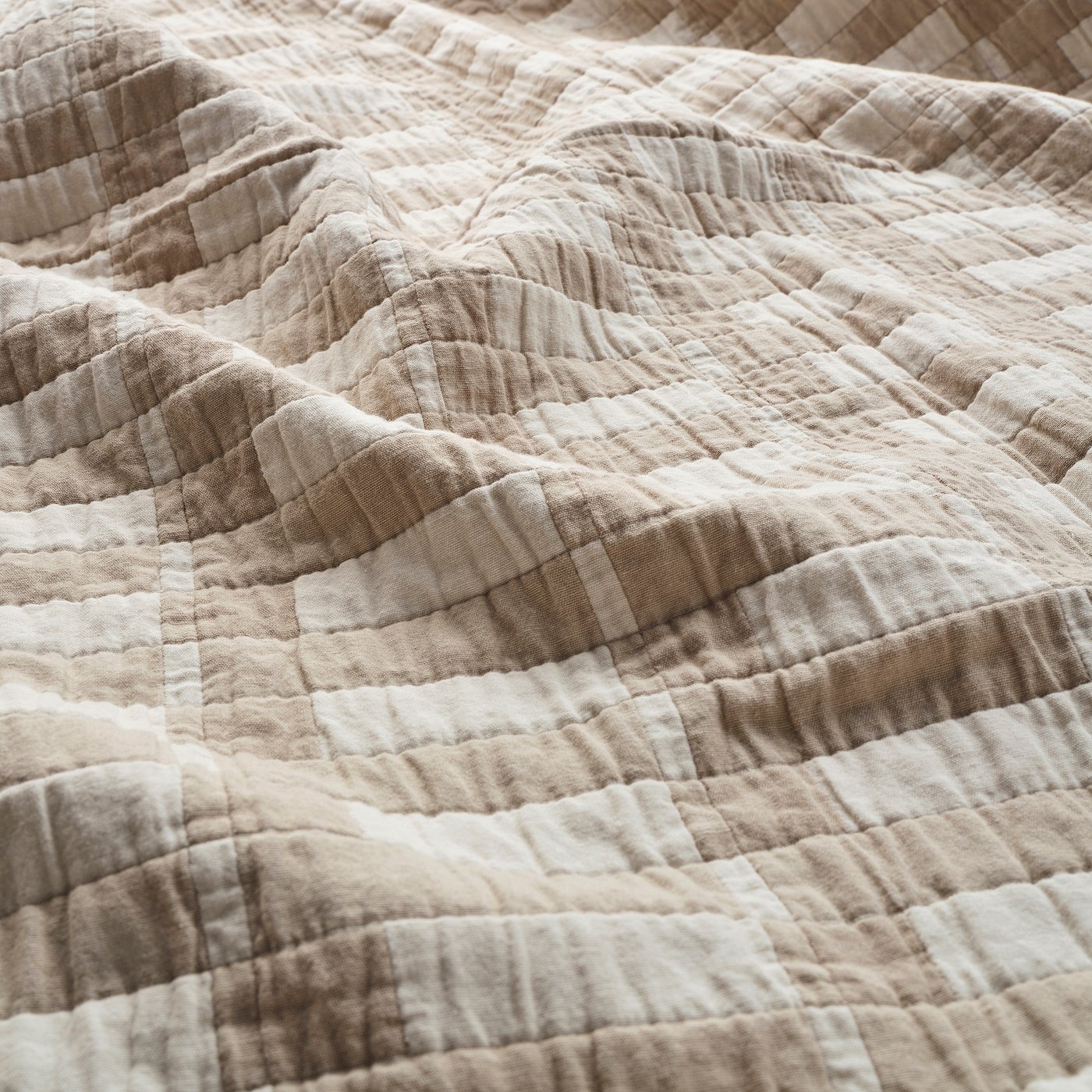 Soft, textured beige blanket with wave-like stitching, showcasing high-quality craftsmanship.