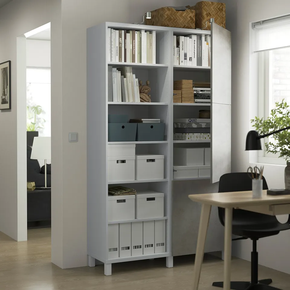 Home office with BESTÅ shelves, desk, chair, and lamp.