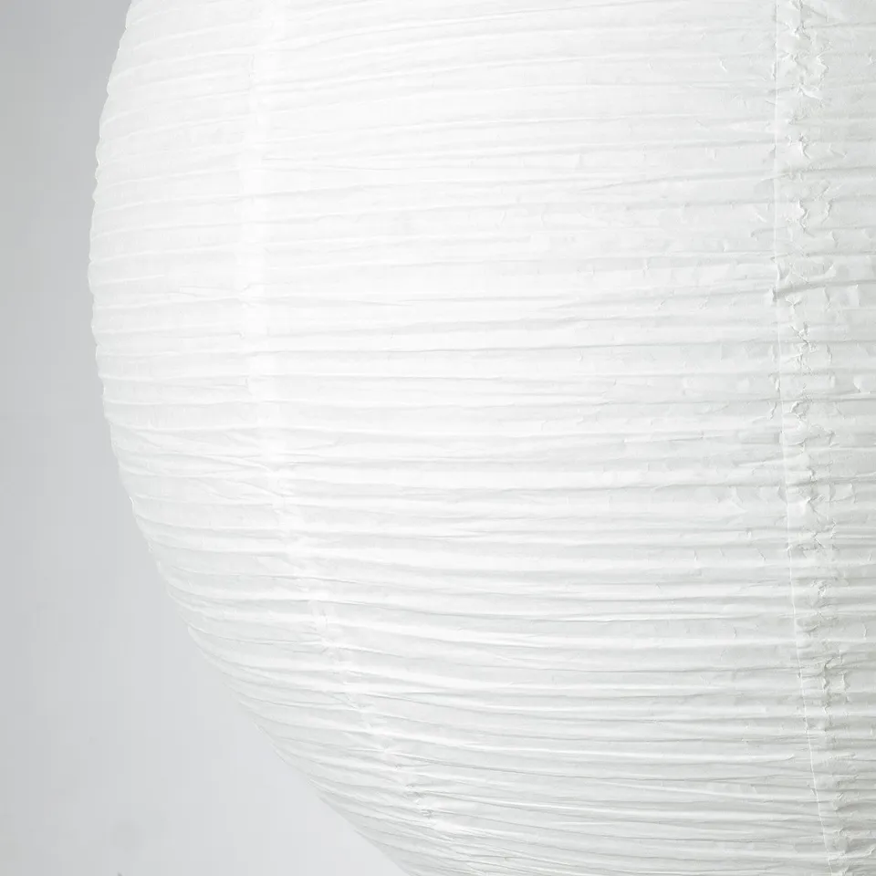 Closeup of a round, handmade rice paper lampshade, showcasing its intricate texture and craftsmanship.