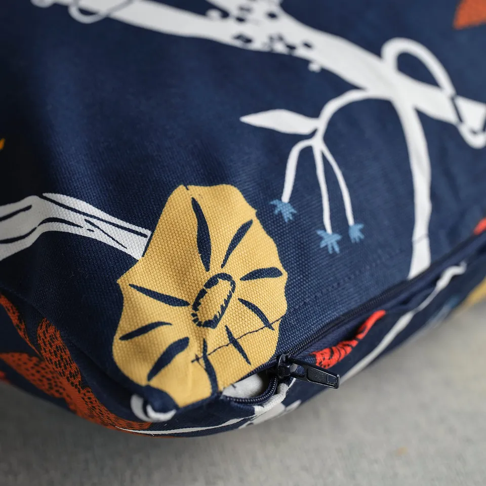 Blue cushion with intricate flower patterns and a zip.