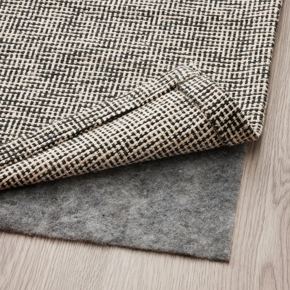 Blacks and whites checker rug with felt underside, perfect for floors, machine washable.