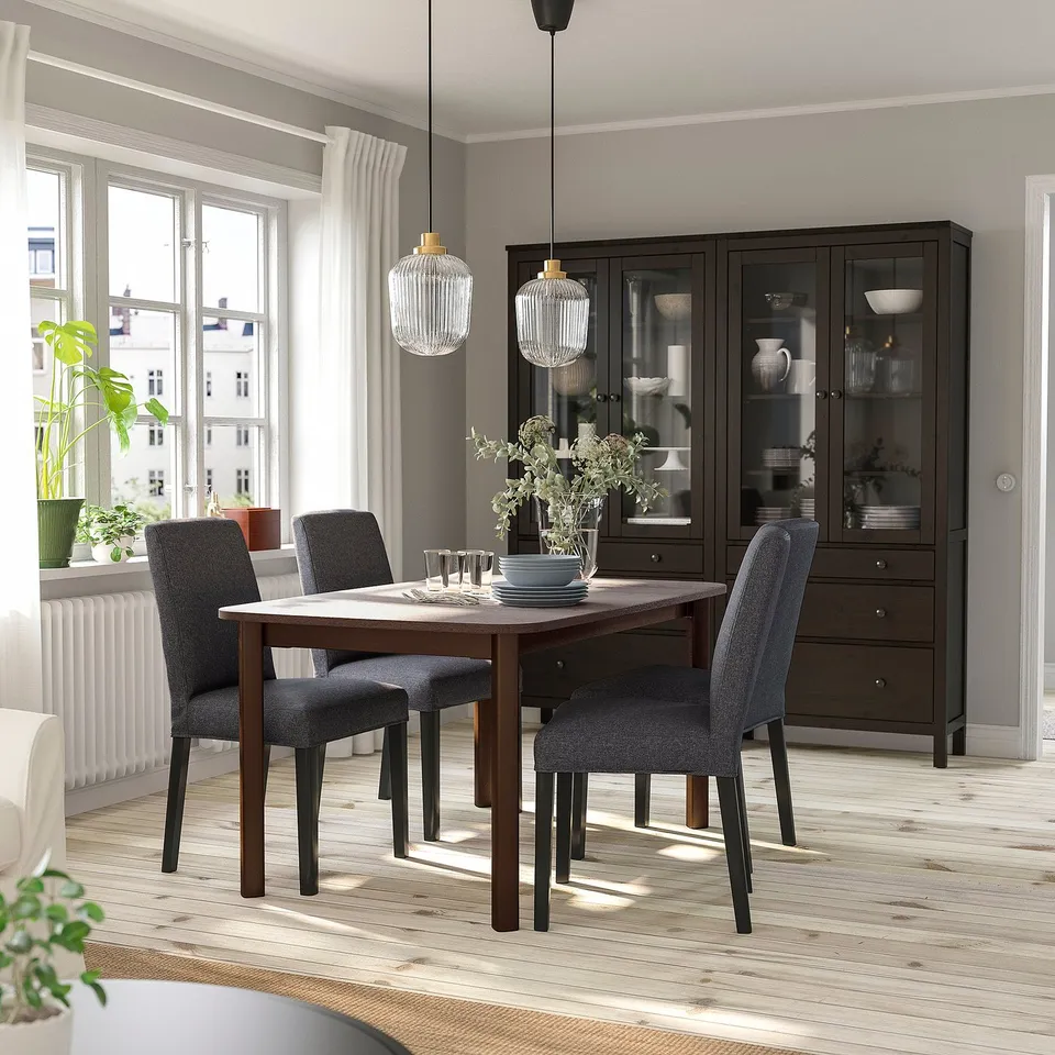 Modern dining room with STRANDTORP table, bergmund chairs, and glass cabinet. Natural light enhances brightness and spaciousness.