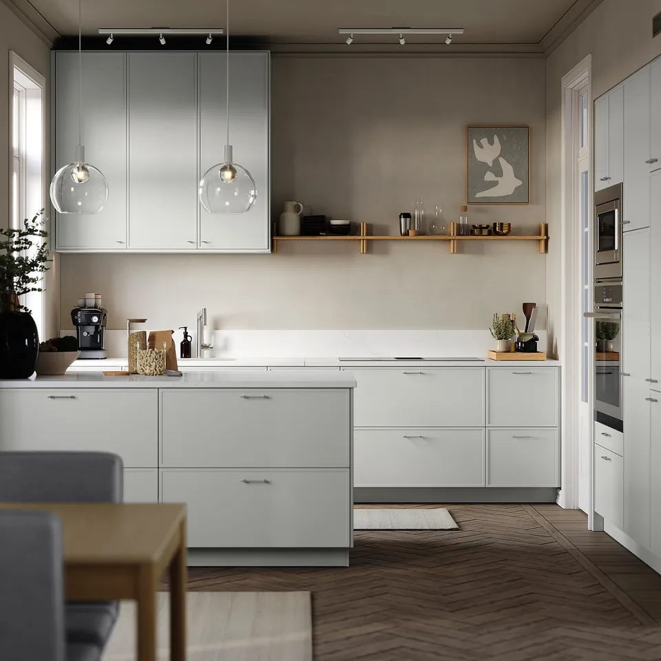 Modern kitchen with white cabinets, wooden floor, hanging lights, and stainless-steel appliances; minimalistic design.