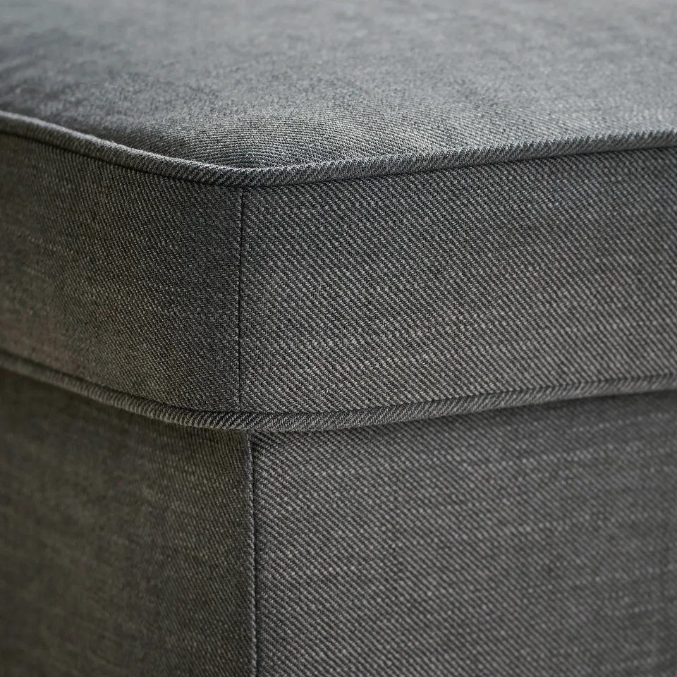 Close-up of STRANDMON upholstery, showing high-quality, durable fabric with neat stitching.