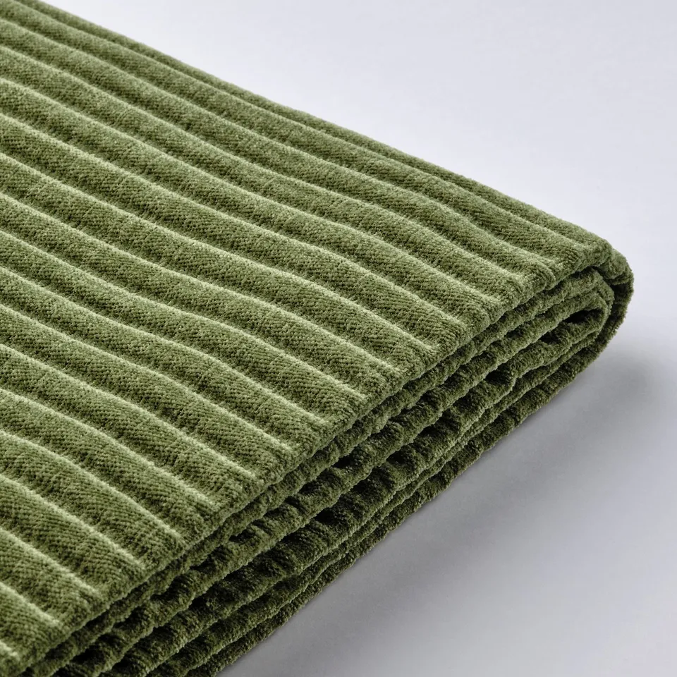 Soft, green, ribbed fabric on a comfortable, modular sofa. Quality texture and design.