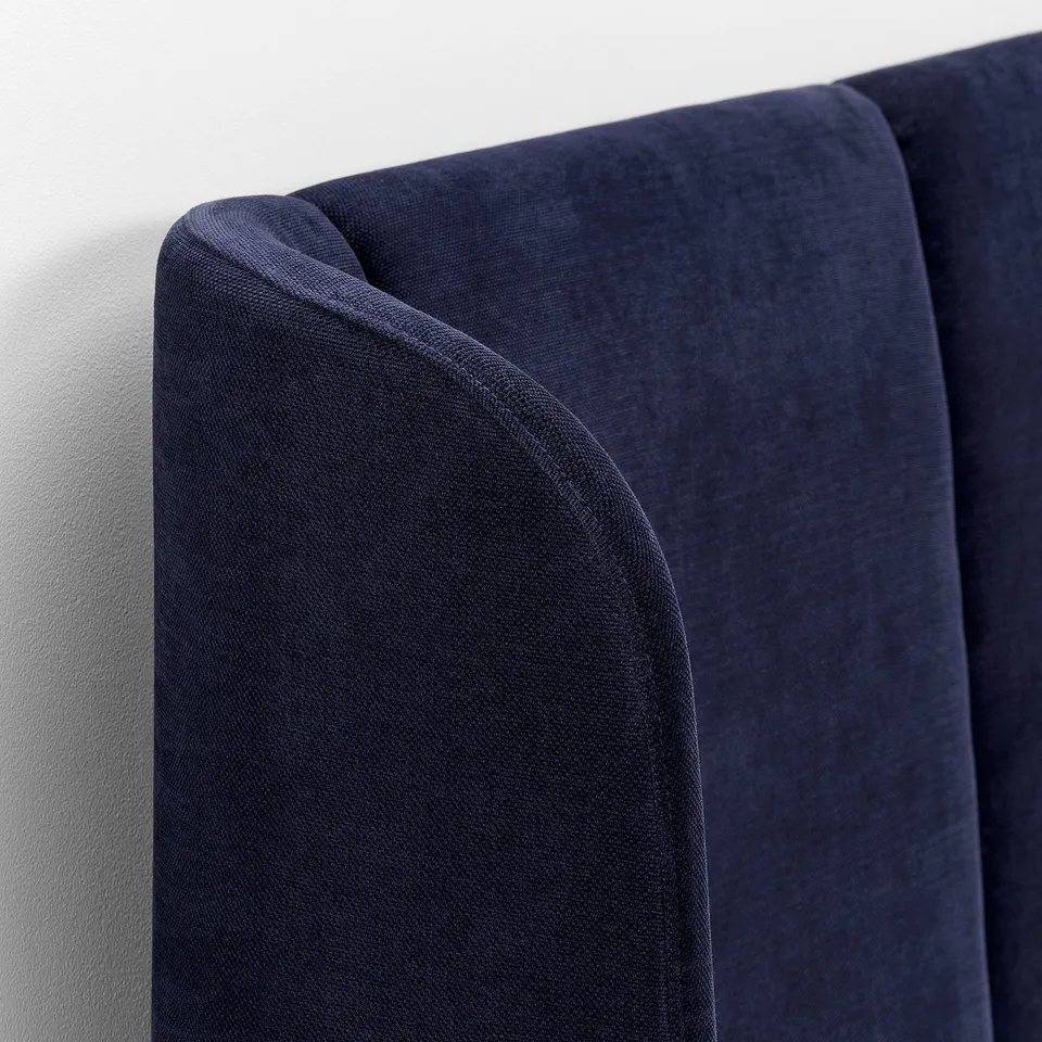 Navy blue headboard with curved edges, soft, high-quality fabric.