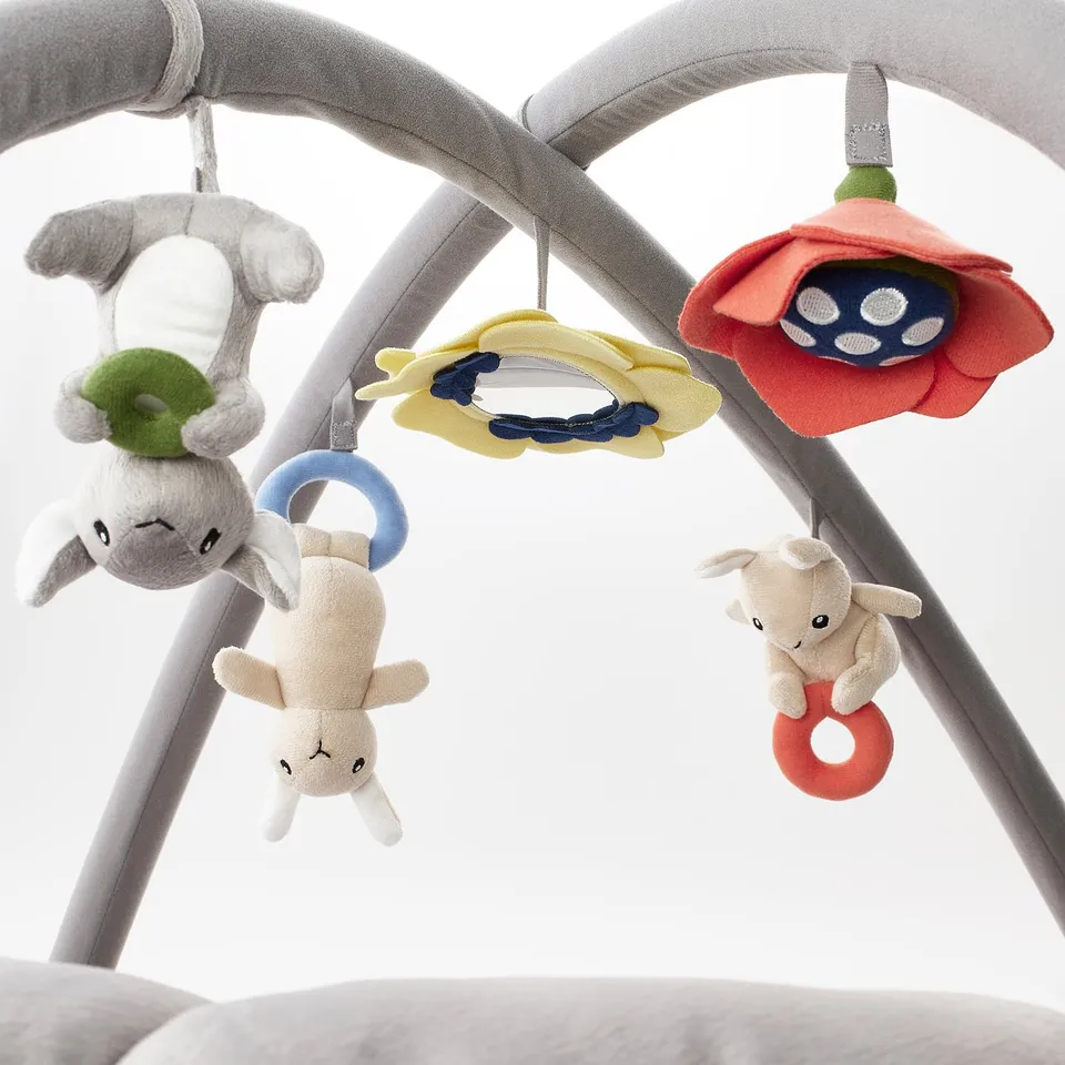 Baby gym with hanging lamb toys, mirror, and flowers. Encourages sensory development and self-discovery.