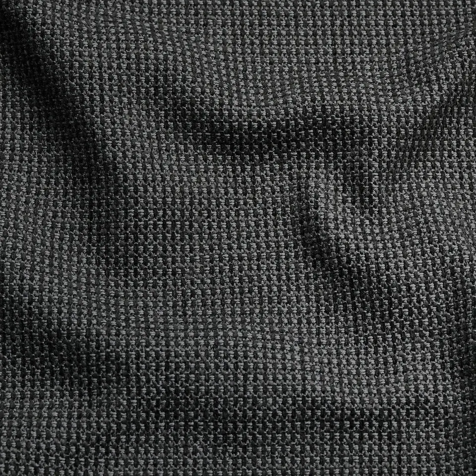 Close-up of textured fabric with subtle sheen, showcasing intricate weave and soft touch. Two-tone effect with recycled materials.