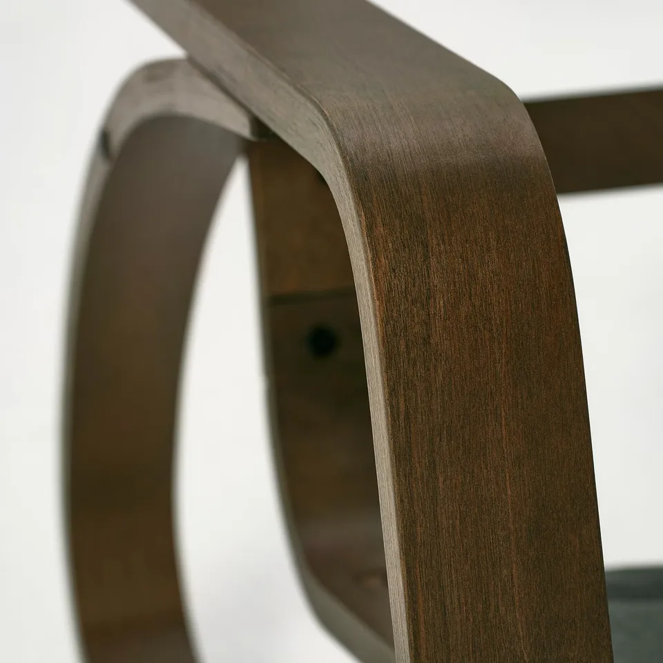 Curved wood rocking chair detail, smooth finish, durable craftsmanship.