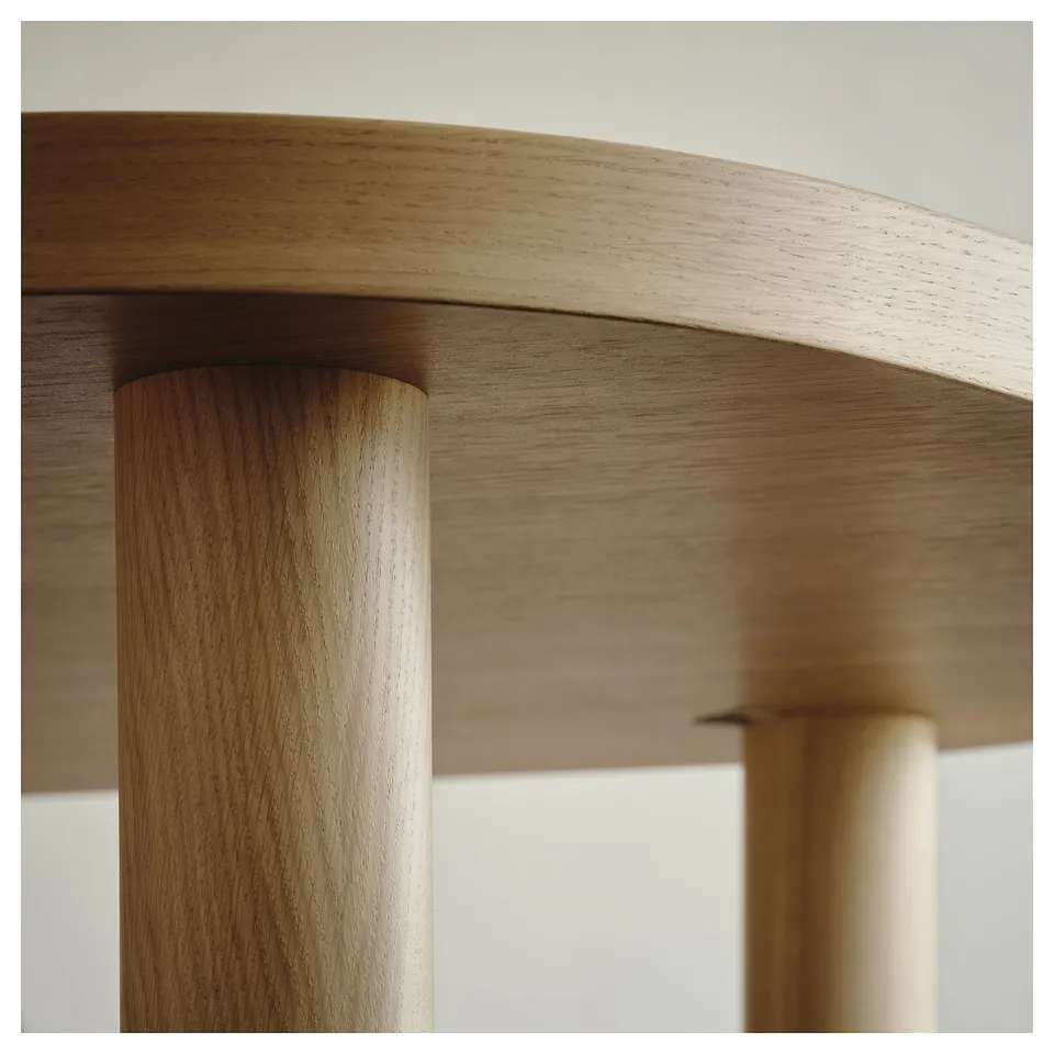 Close-up of a sturdy, well-crafted wooden table with smooth, natural oak veneer finish. High-quality assembly with visible wedge dowels.
