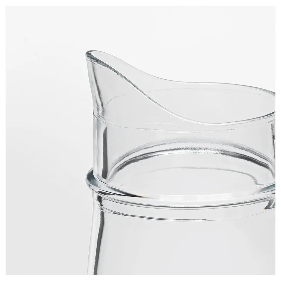 Translucent glass jug with sturdy handle, smooth curves, and wide opening. Ideal for beverages or decorative use.