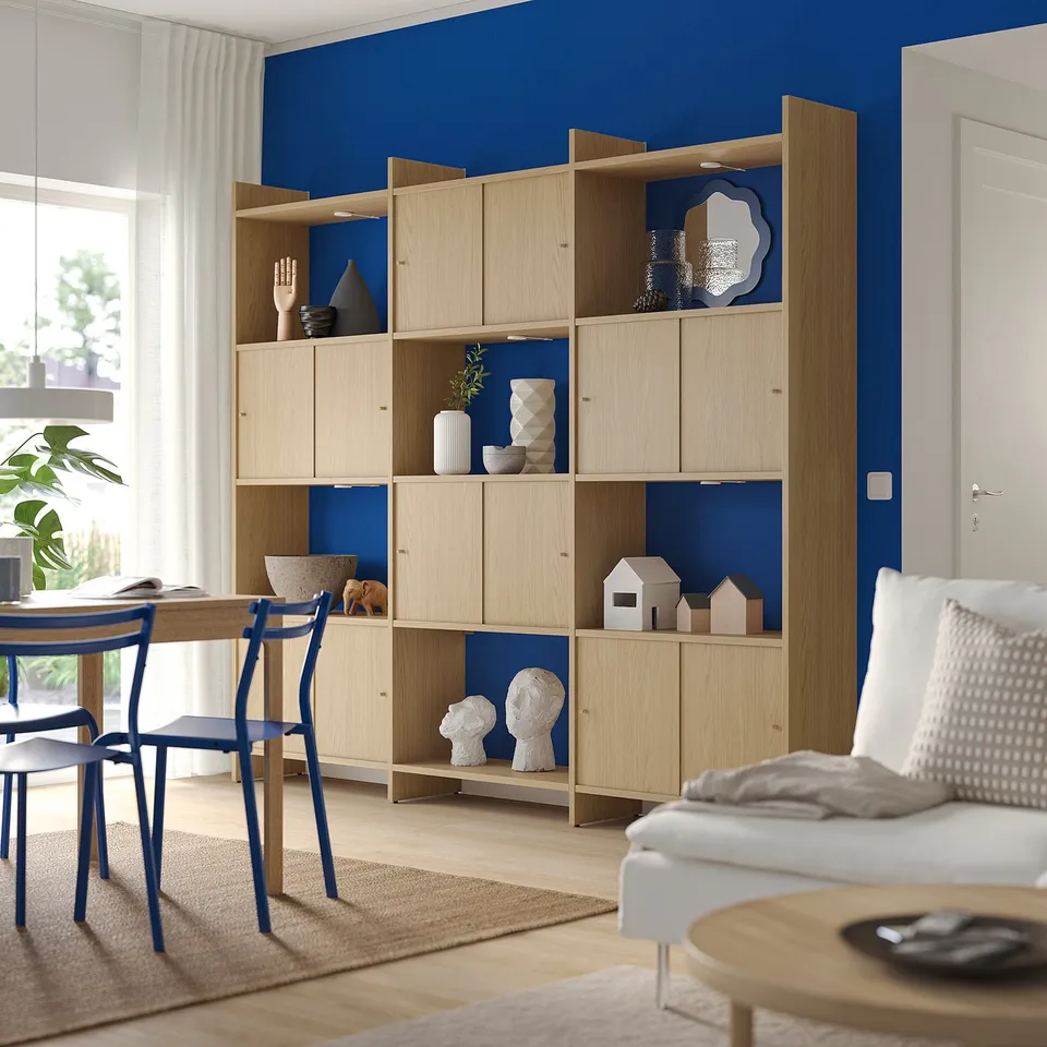 Modern living room with LÅDMAKARE bookshelf in light wood and blue accents, featuring open shelves and decorative items.