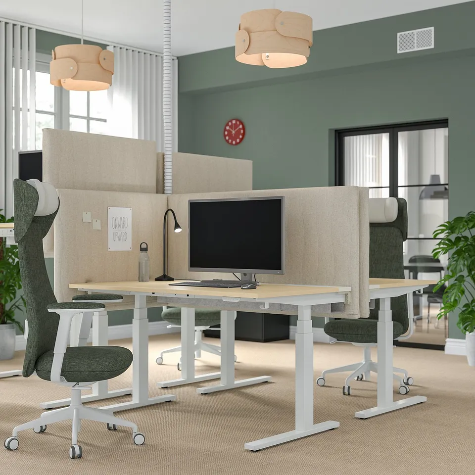 Modern office with MITTZON acoustic desk, beige screens, wood desk, green chairs, unique lights, red clock.