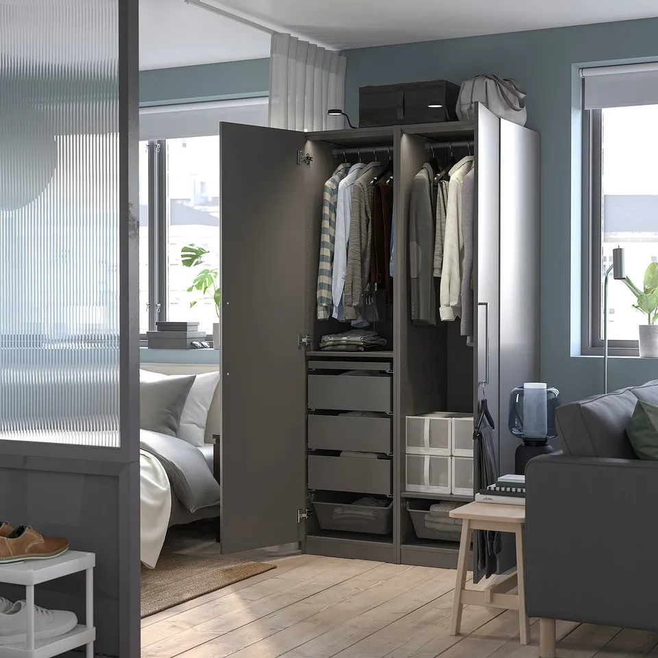 Open wardrobe with clothes hangers, drawers, and baskets, showing organisation inside.
