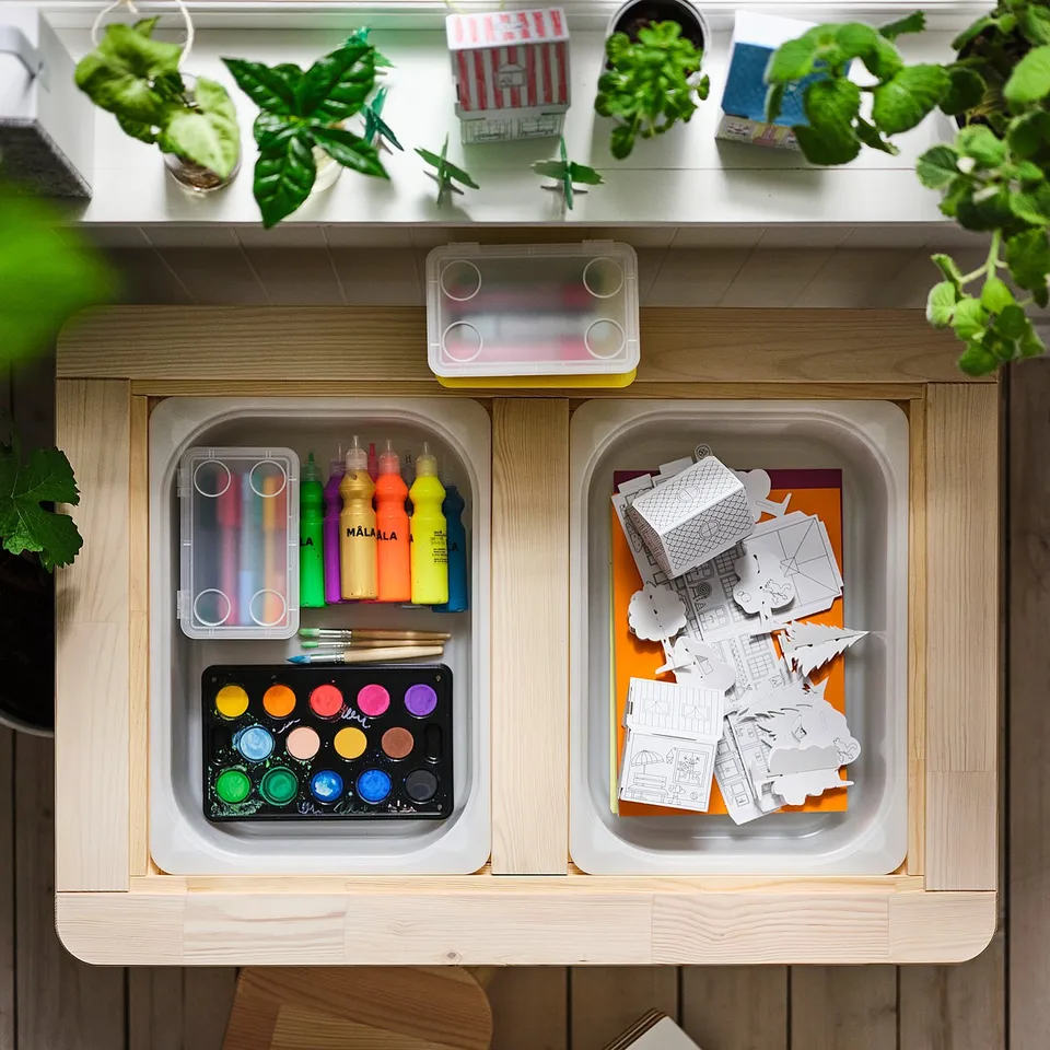 Wooden craft storage unit filled with art supplies and cardboard building templates, ideal for childrens creative play.