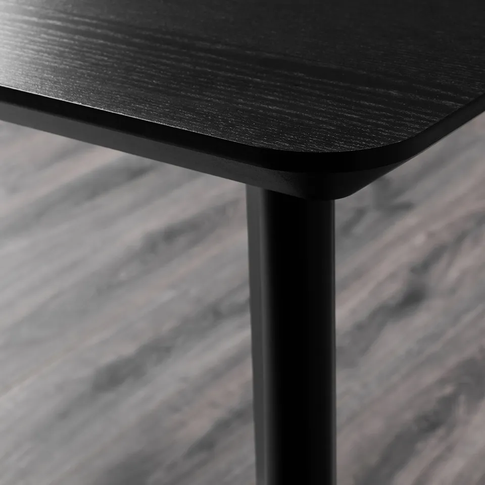 Close-up of a modern black table with sleek design and strong legs.