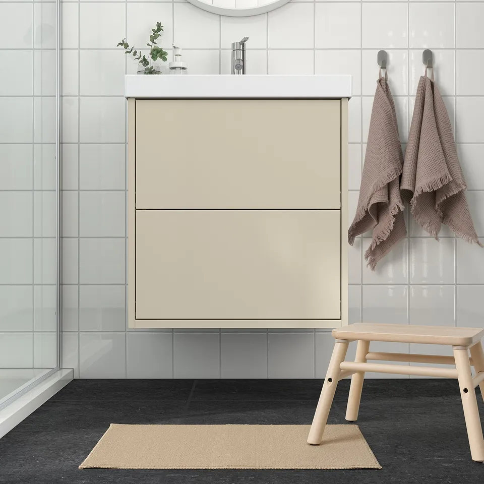 Minimalist bathroom with beige FINTSEN bath mat made of recycled polyester, blending with neutral decor.