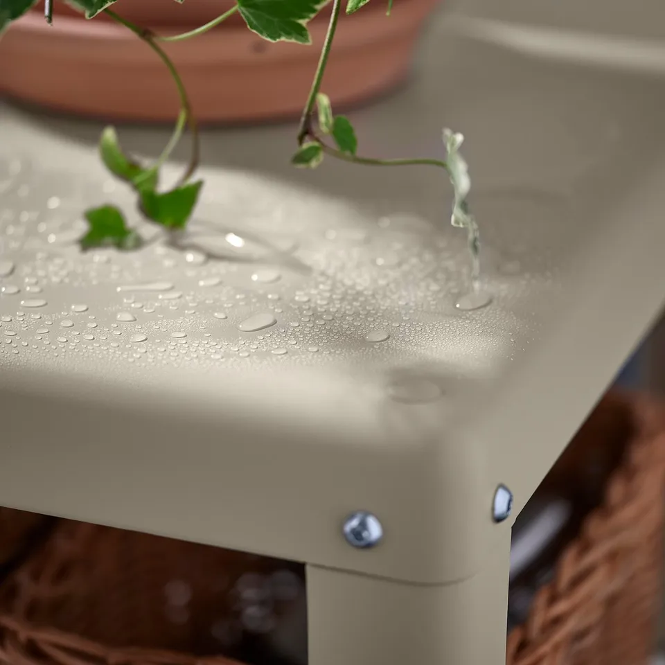 Metal shelving with water droplets, small green plant, adjustable feet.