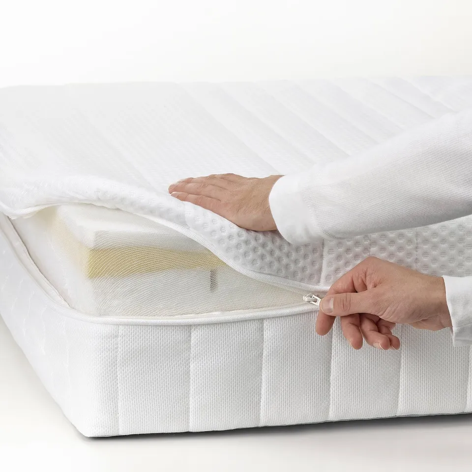 Person zips open white mattress cover. Shows memory foam layer inside. Demonstrates mattresss design for comfort and support.