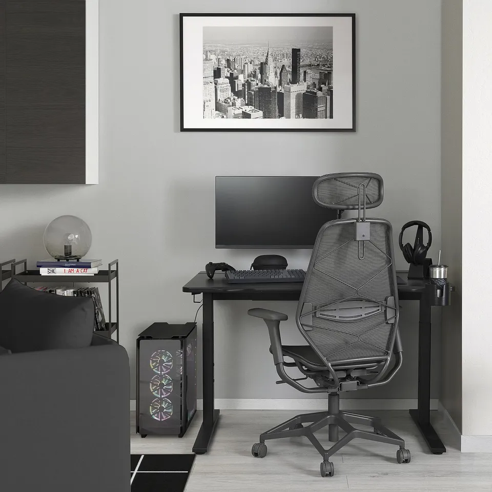Gaming desk setup with black/gray UTMANING desk, ergonomic chair, and accessories.