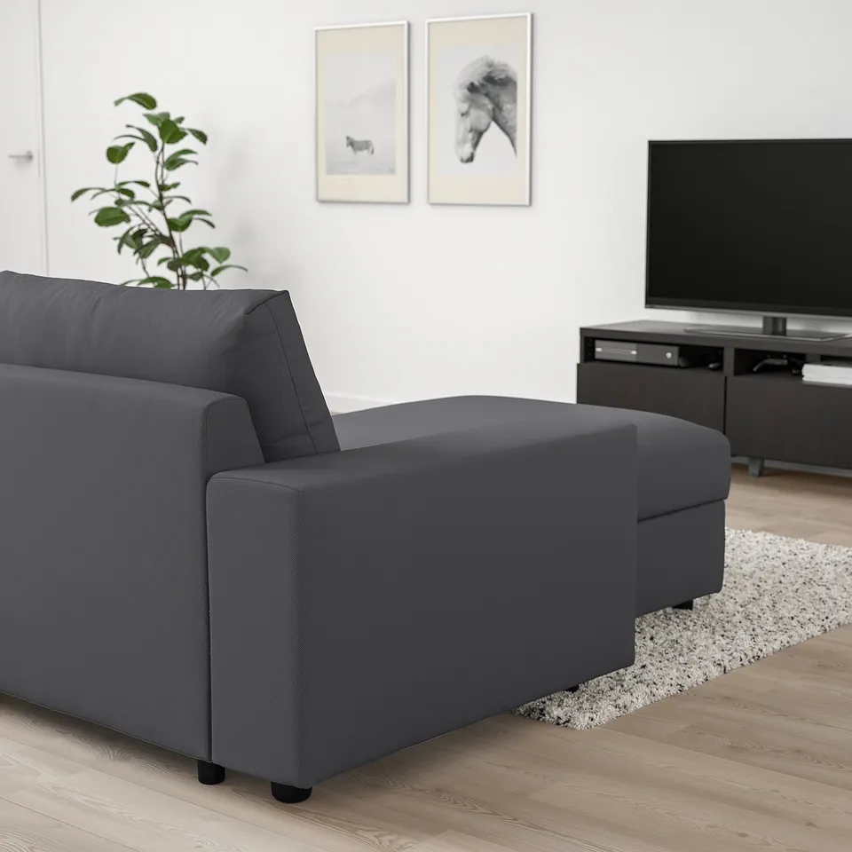 Contemporary living room with dark grey VIMLE sectional sofa. Accented by modern decor and flat-screen tv.