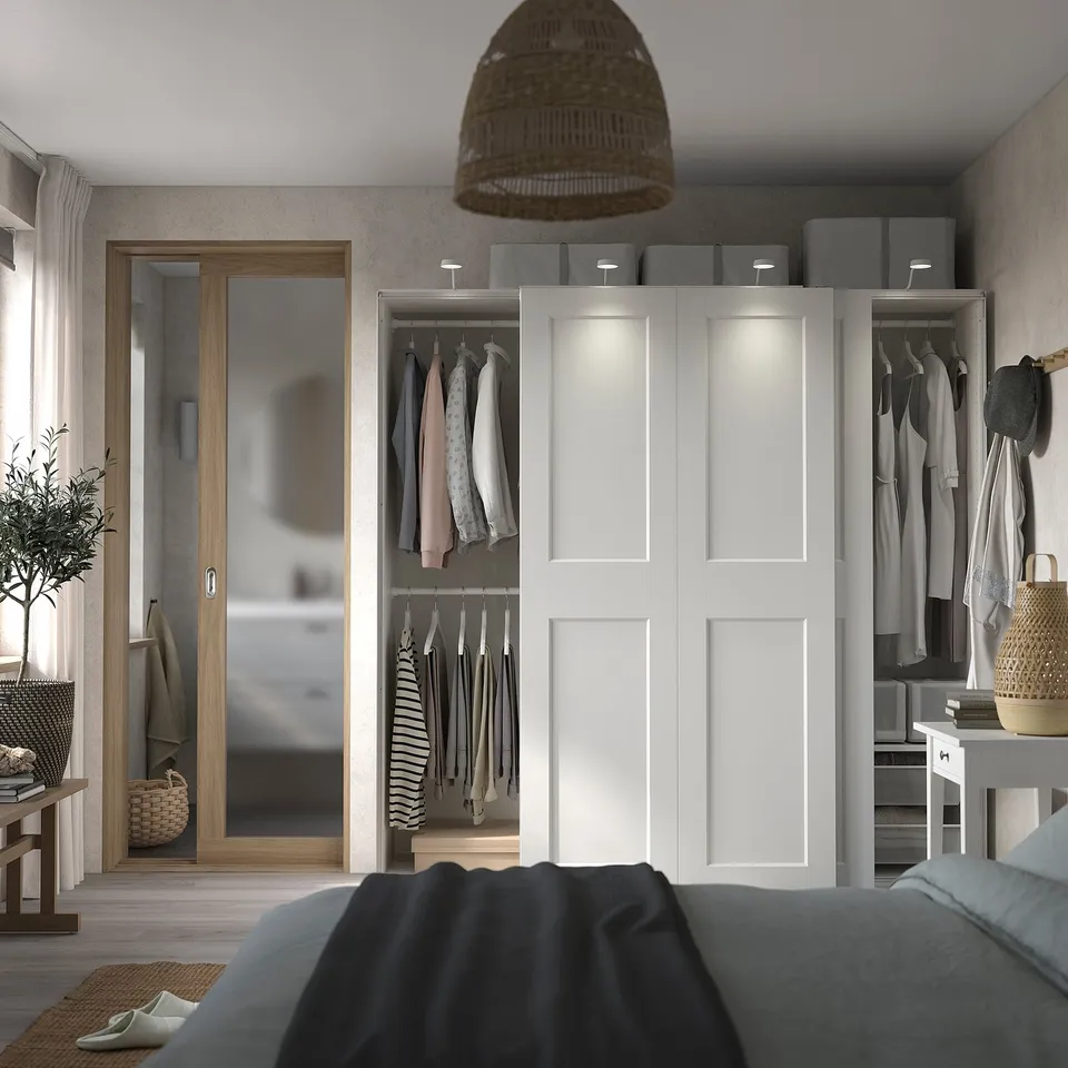 Modern bedroom with PAX wardrobe, bed, basket, mirror, and pendant lamp.