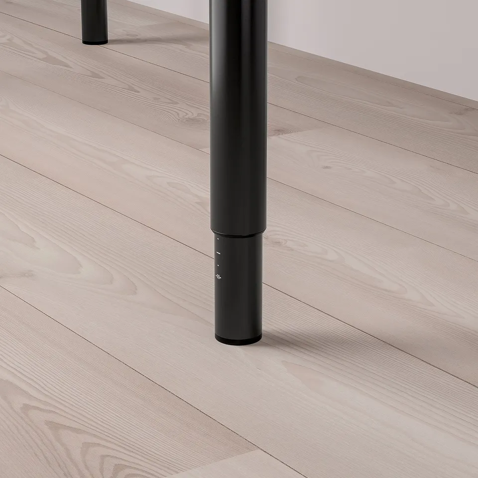 Black metal table leg on light wooden floor.