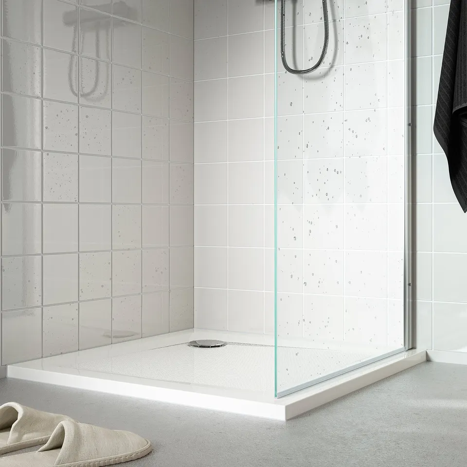 A modern, low-profile shower tray with anti-slip surface, featuring a sleek design that complements any shower enclosure.