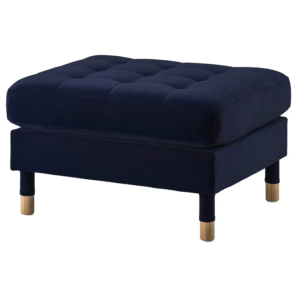 Blue velvet footstool with tufted top and wooden legs.