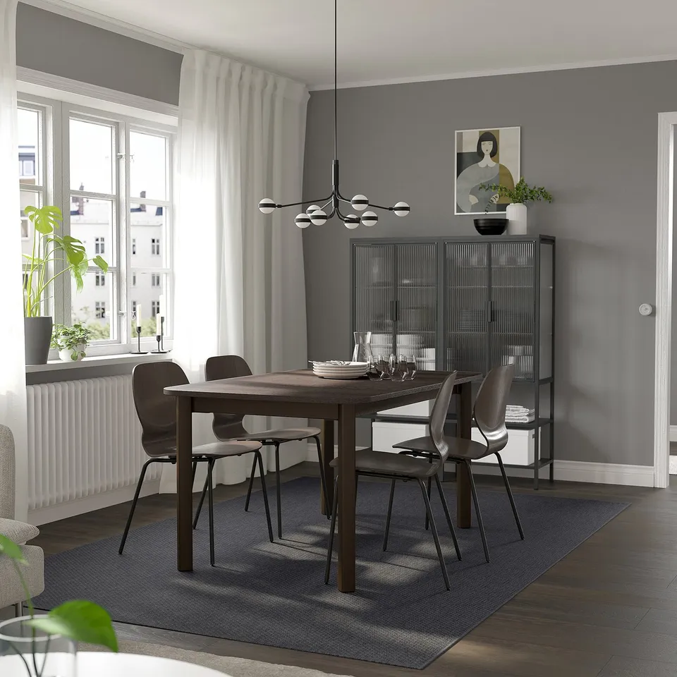 Grey dining room with STRANDTORP table, chairs, pendant light, large window, rug, and storage cabinet.