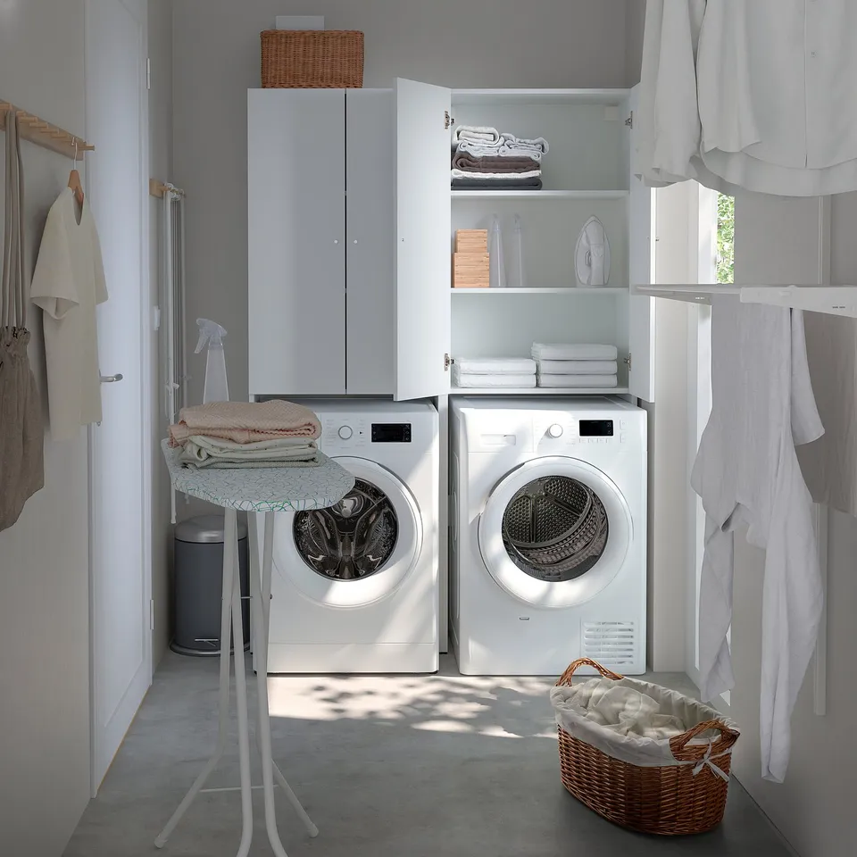 Laundry room with storage, washing machine, dryer, and clothes. Or organised laundry room with machine, storage, and clothes.