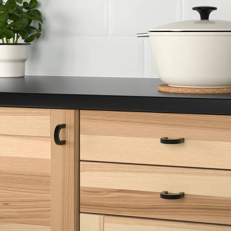 Modern kitchen with wooden cabinets and metal handles.