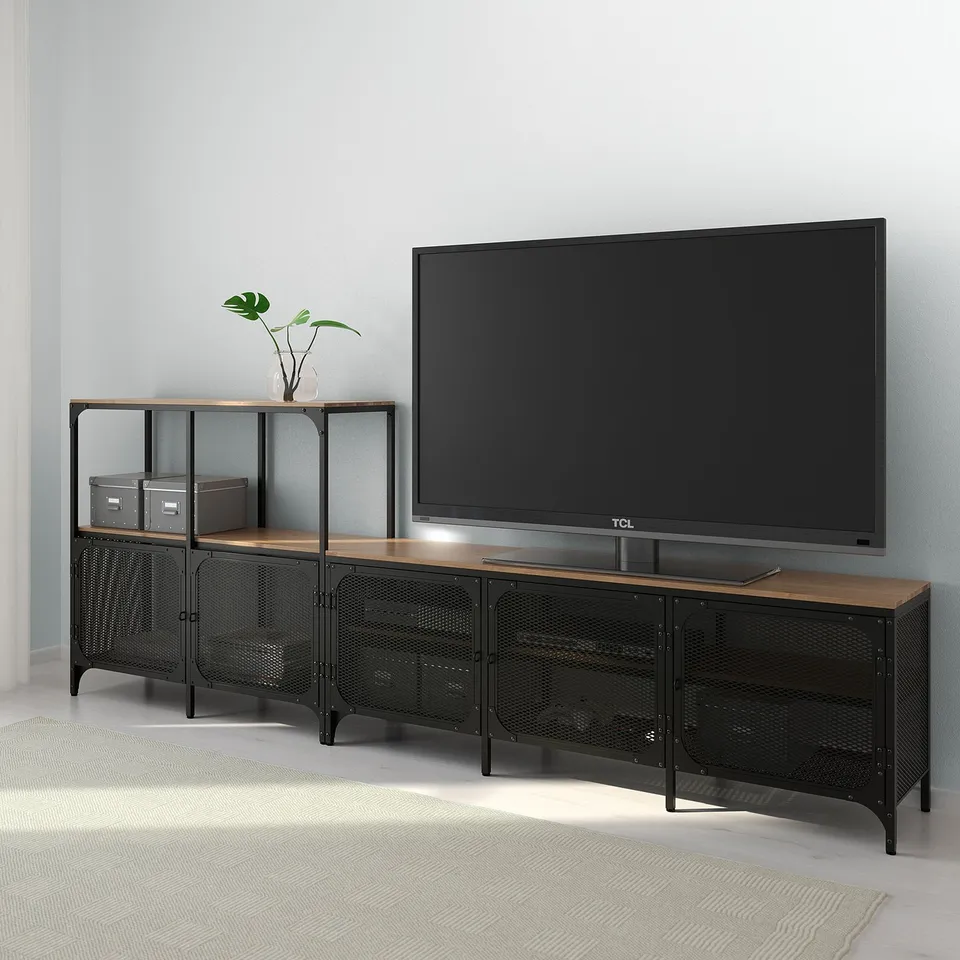 Modern tv stand with mesh doors, wood top, and adjustable feet. A large flat-screen tv and a potted plant.