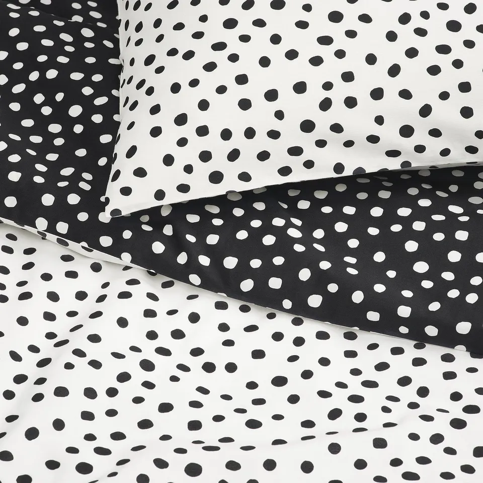 Black and white dotted duvet set, smoothly textured, laid neatly.