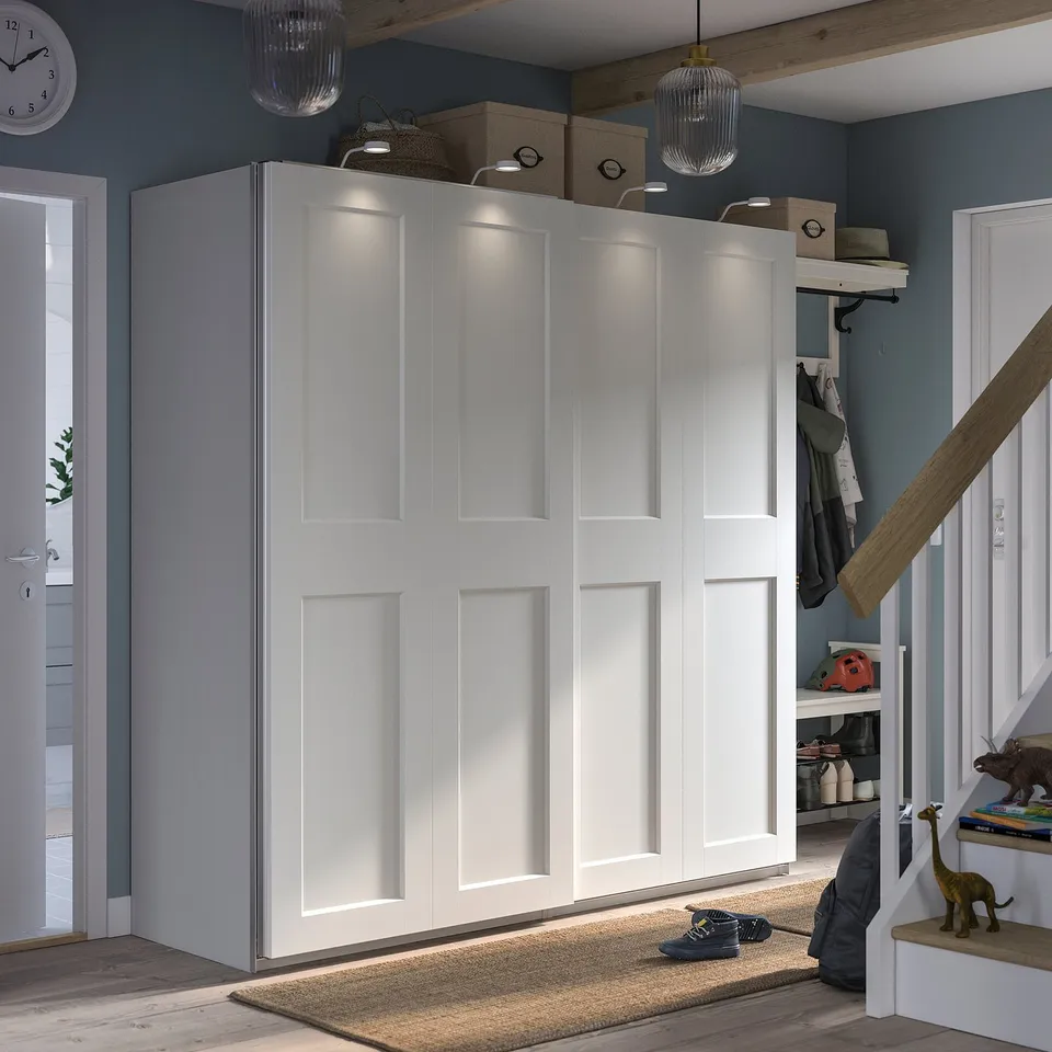 A white PAX wardrobe with sliding doors and built-in lighting. Its a modern, minimalist design ideal for smaller spaces.