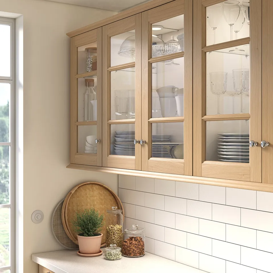 Wooden kitchen cabinets with glass panels and counter items.
