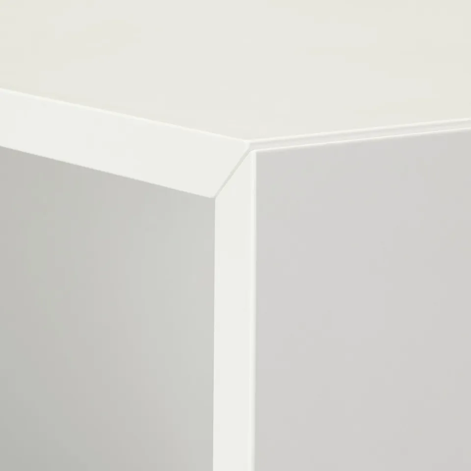 Crisp, white corner of modern furniture; sleek design; clean finish.