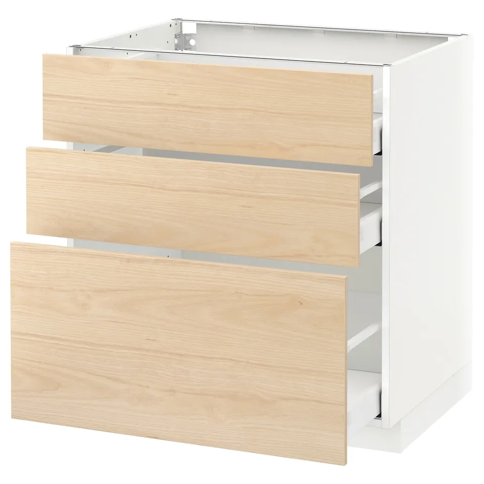 A white METOD kitchen cabinet with three light ash wood drawers, partially open.