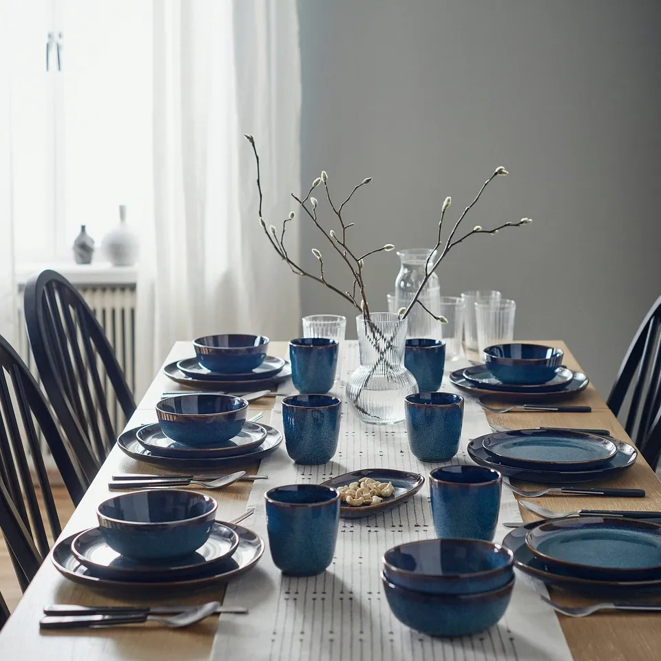 Blue GLADELIG tableware with golden rims, handcrafted look. Centred vase with branch decor.