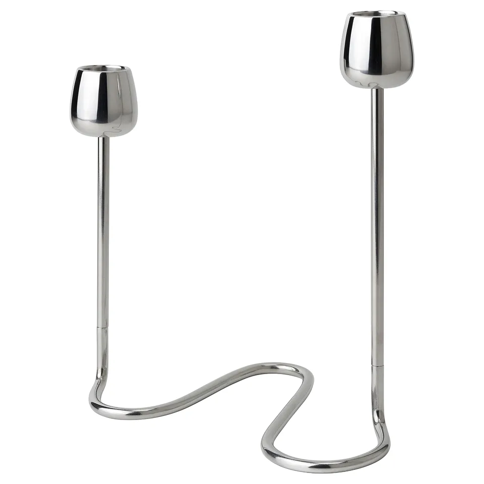 The SILVERPÄRON set includes two stainless steel candlesticks with curved, stem-like bases and rounded cups, reflecting natural flower designs.