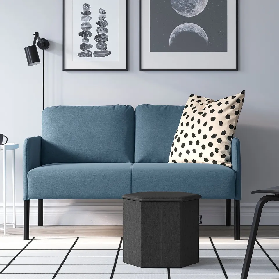 Teal GLOSTAD loveseat with polka dot pillow, framed wall art, black side table, small chair, modern minimalist room.