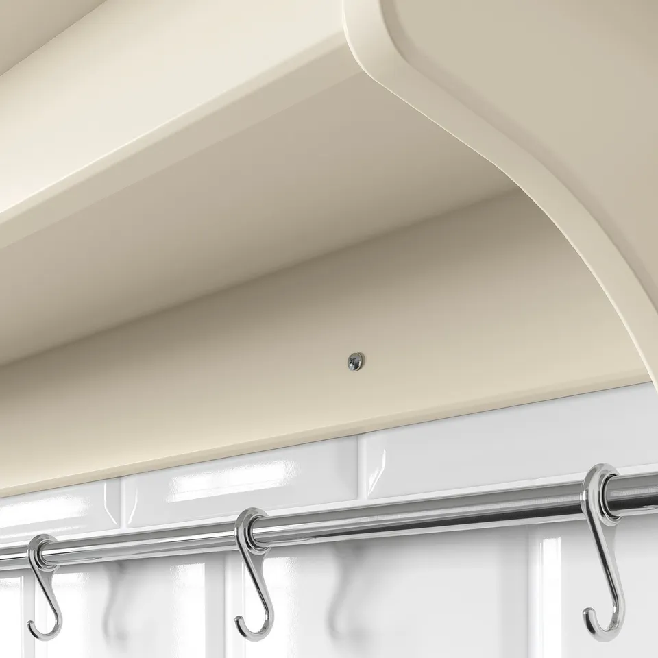 White wall shelf with metal rail and hooks.