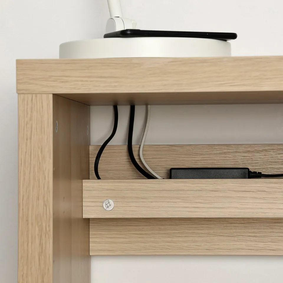 Wooden shelf with holes for cable management, featuring visible cables and a charger on the top shelf.