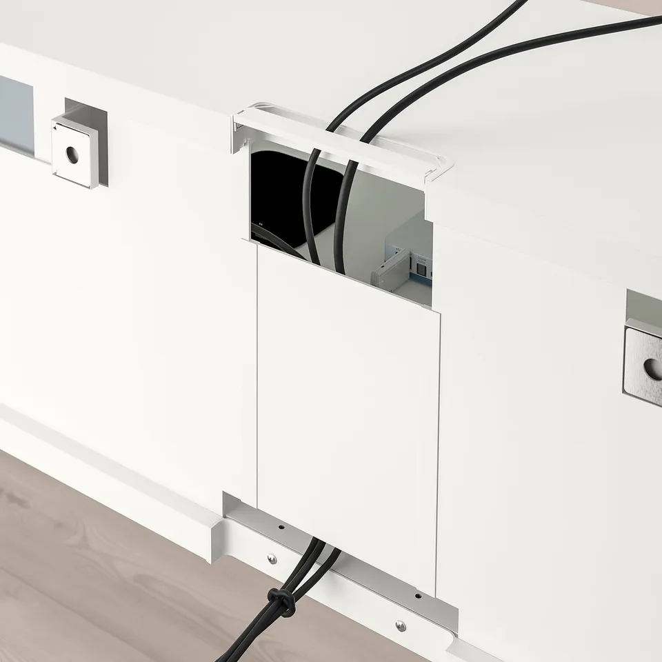 A BESTÅ tv storage unit with adjustable shelves and cable management, including a wall-mounted compartment with cable outlets.