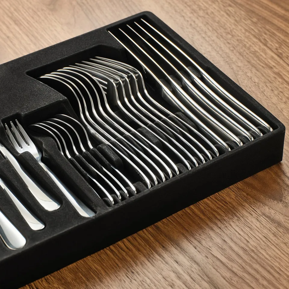 Polished stainless steel cutlery set in black tray, neatly organised, reflecting light, quality design.